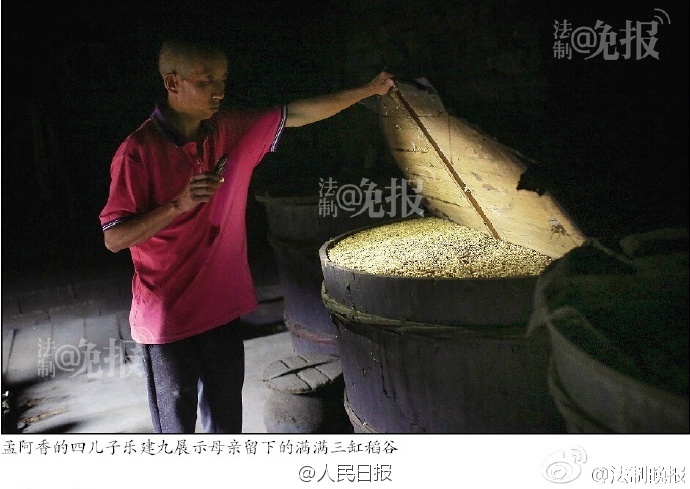 孟阿香的四儿子乐建九展示母亲留下的满满三缸稻谷