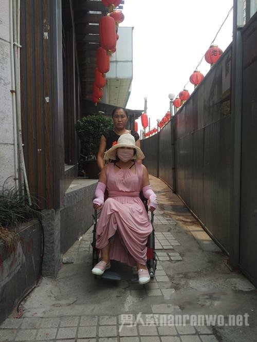 整形狂人坐在椅子上由保姆推着走