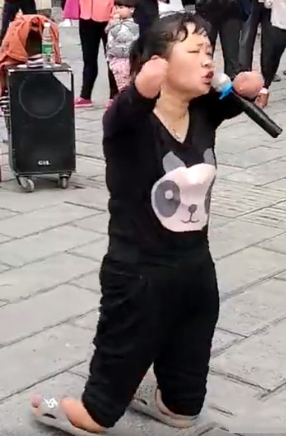 女子当街卖唱乞讨