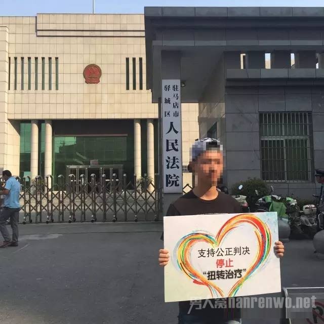 志愿者在驻马店驿城区人民法院门口举牌支持余虎