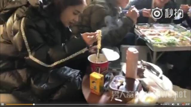 angelababy自己独自坐在一个小圆桌上吃着泡面