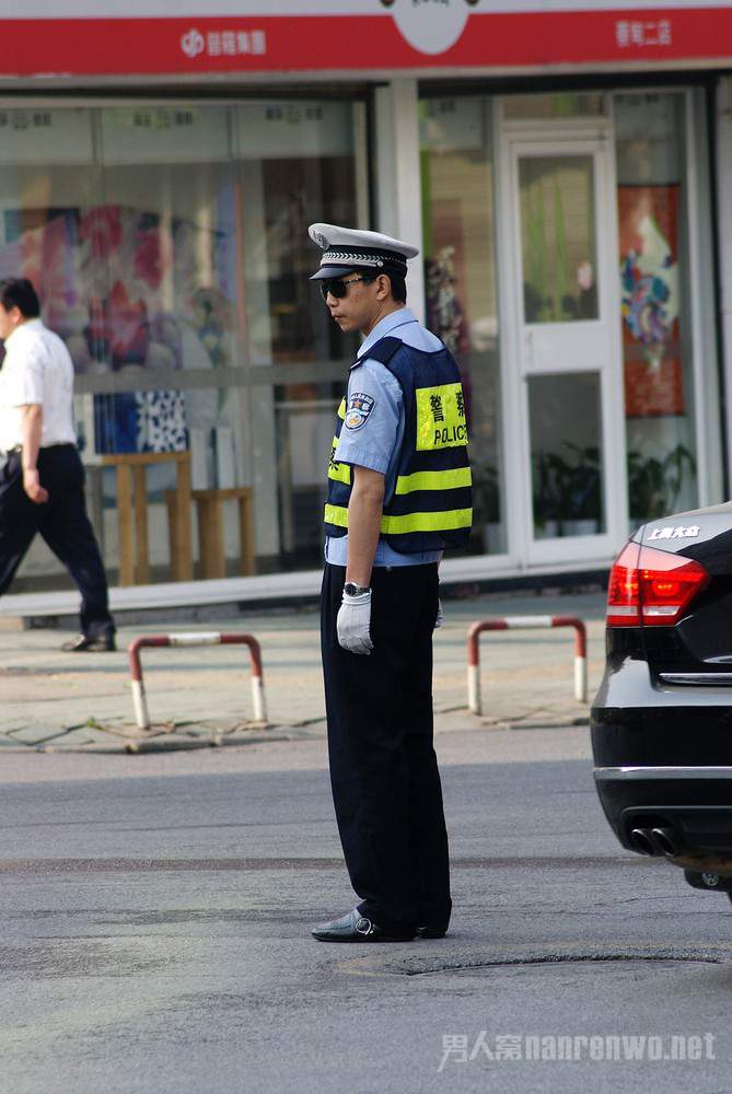 醉酒男子推着车走过交警